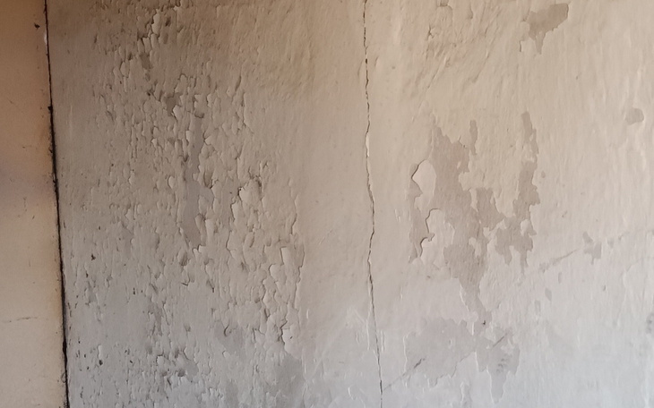 Zbliżenie na ścianę z łuszczącą się farbą.