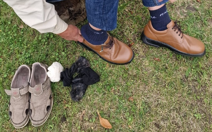 Mężczyzna zakłada nowe buty na trawie.