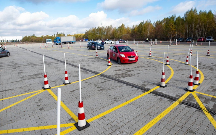 Plac manewrowy z samochodami i pachołkami.