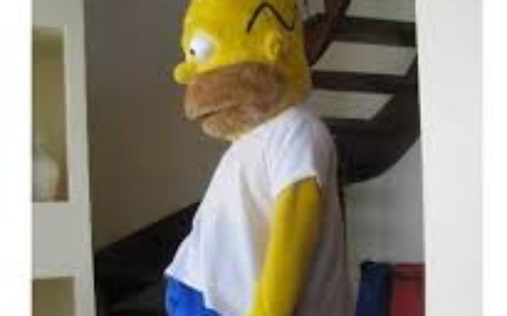 Homer Simpson w kostiumie, stojący na schodach.