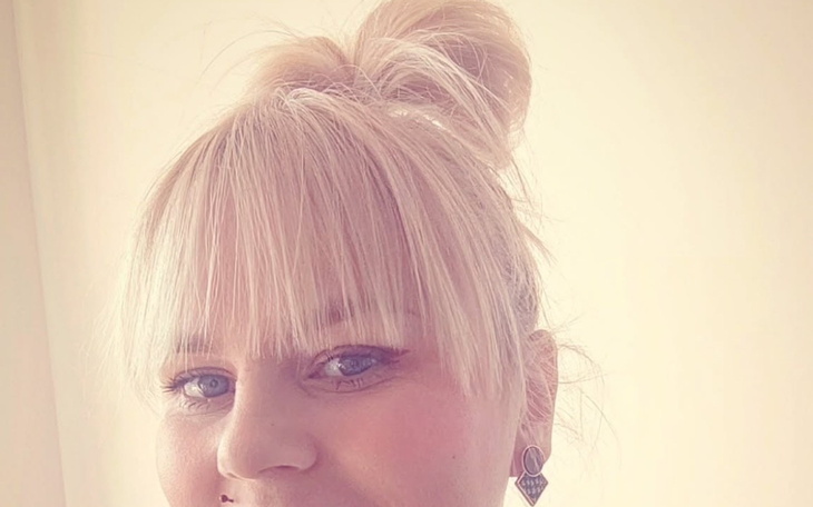 Kobieta z jasnymi włosami i kokiem w zbliżeniu.