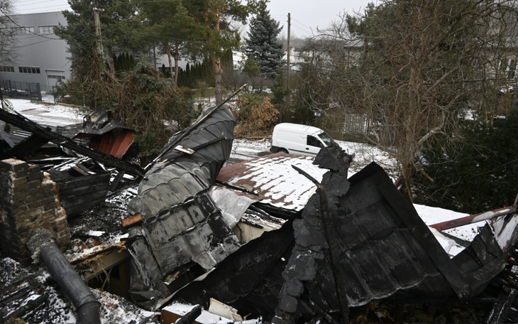 Widok na zniszczony dach budynku, pokryty śniegiem.