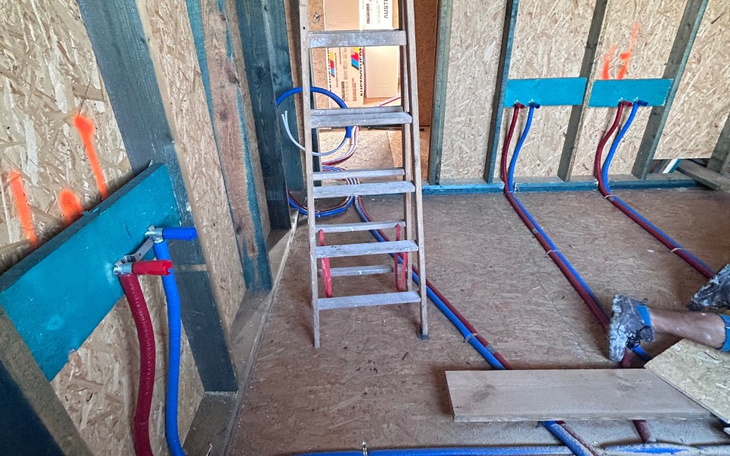 Wnętrze budynku w trakcie budowy, widoczne instalacje.