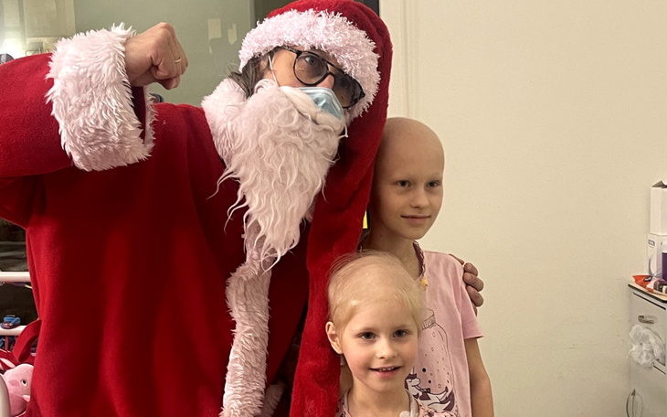 Mikołaj z dziećmi, w tym z dziewczynką z łysinką.