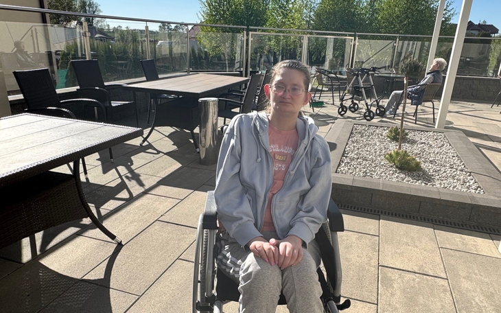 Młoda dziewczyna na wózku inwalidzkim, spędza czas na tarasie.