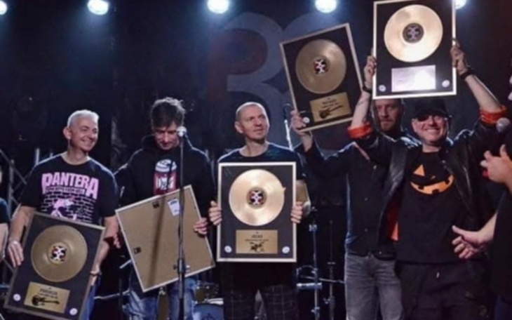 Zespół muzyczny z nagrodami na scenie.