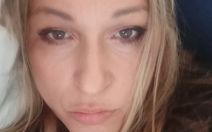 Portret kobiety z długimi włosami, patrzącej w kamerę.