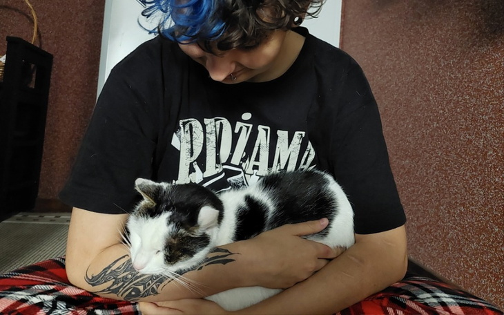 Osoba przytulająca kota, wyrażająca miłość i czułość.