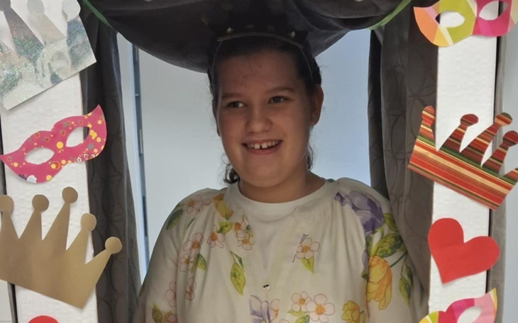 Dziewczynka w przebraniu, uśmiechająca się w kreatywnej scenerii.