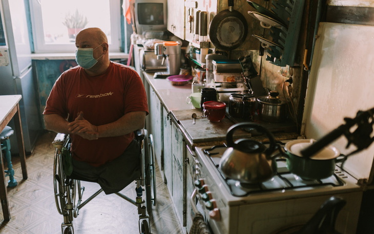 Mężczyzna w wózku inwalidzkim w kuchni.