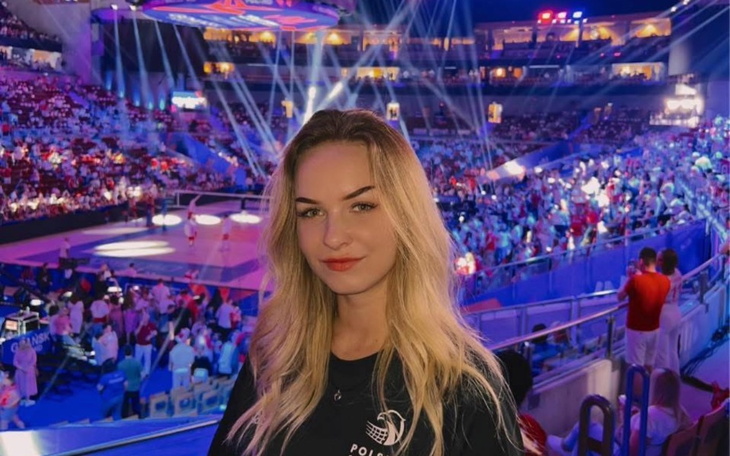 Młoda kobieta na tle tłumu, w miejscu wydarzenia sportowego.