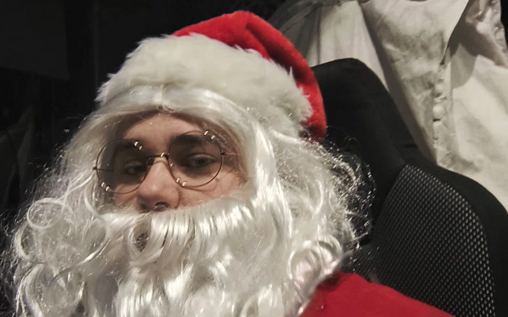 Osoba przebrana za Świętego Mikołaja z białą brodą.