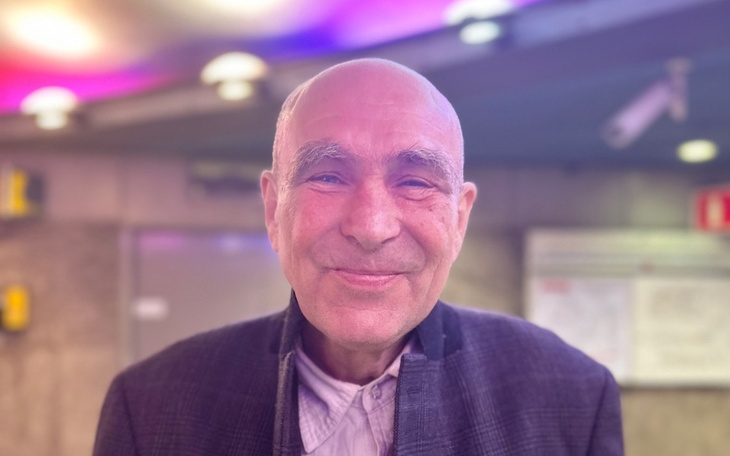 Uśmiechnięty mężczyzna w jasnym otoczeniu, z radością na twarzy.