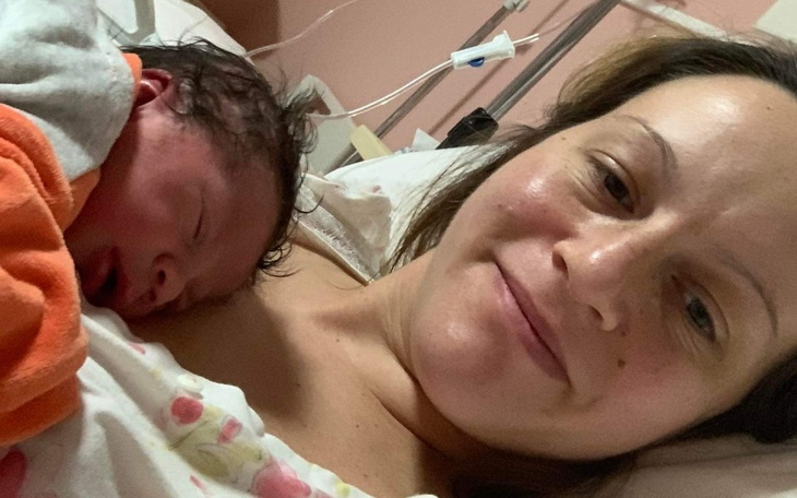 Mama trzyma noworodka na piersi, oboje wyglądają na szczęśliwych.