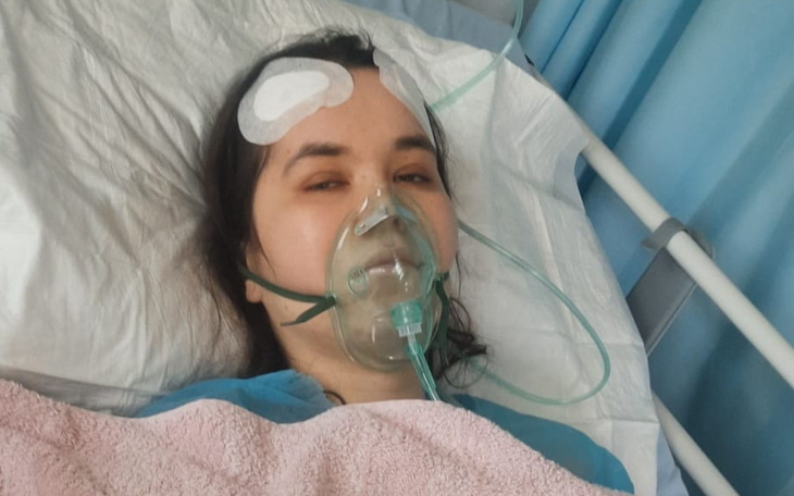 Kobieta w szpitalu z tlenem na twarzy.