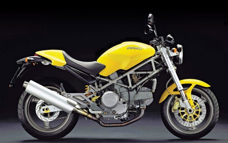 Motocykl Ducati w intensywnym żółtym kolorze na czarnym tle.