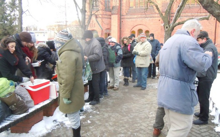 Ludzie czekający w kolejce na jedzenie w zimowy dzień.