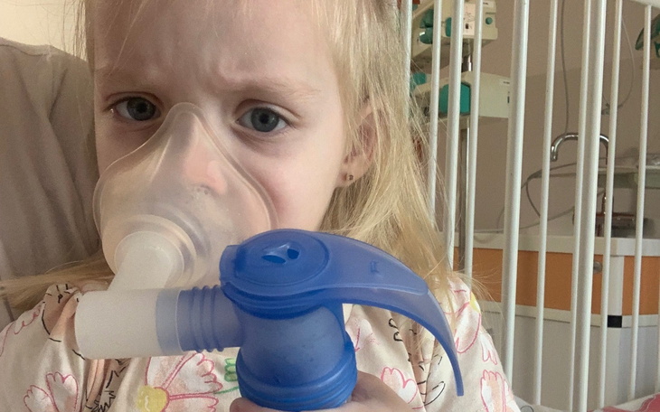 Mała dziewczynka z maską tlenową w szpitalu.