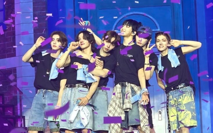 Grupa przyjaciół na scenie, otoczona konfetti, celebrująca wspólny moment.