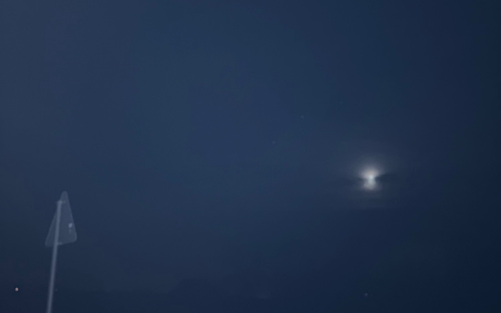 Nocne niebo z widocznym księżycem w chmurach.