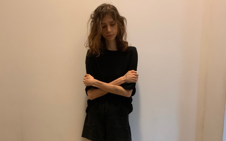 Młoda kobieta w czarnym stroju, z zamyśloną miną.