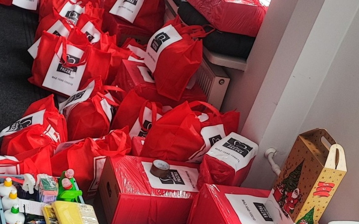 Czerwone torby z darami, przygotowane na świąteczną akcję.