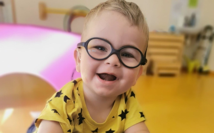 Uśmiechnięty chłopiec w okularach, bawiący się w przedszkolu.