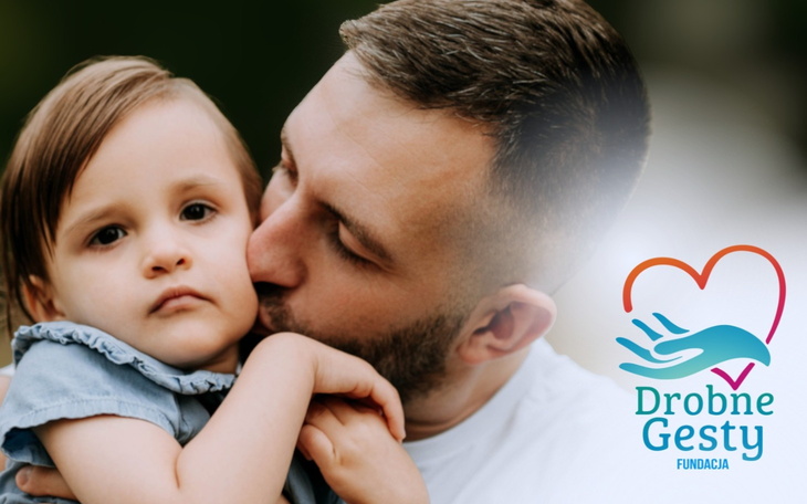 Rodzina spędzająca czas razem, uśmiechnięte dziecko w ramionach ojca.