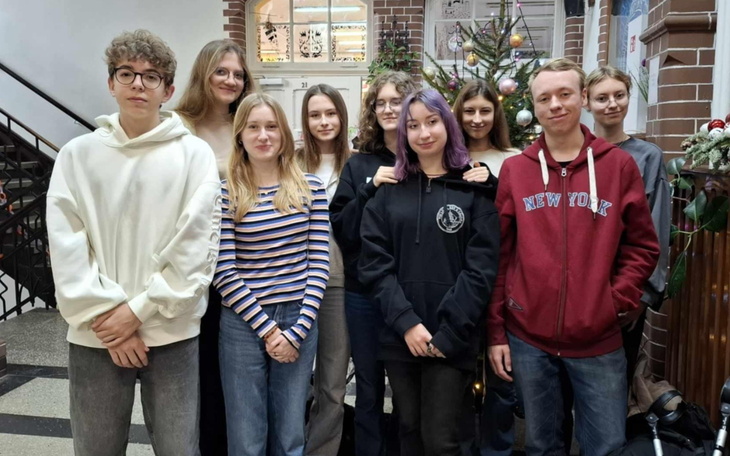 Grupa młodych ludzi pozująca do zdjęcia w szkole.