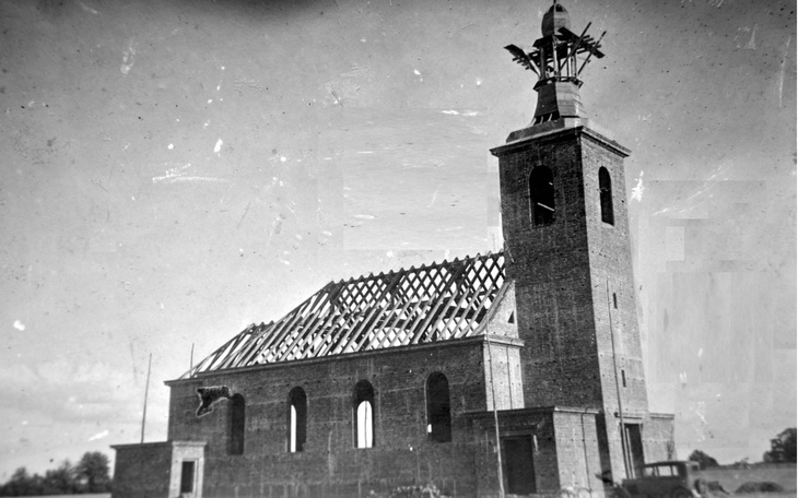 Zniszczony kościół z brakującym dachem, w tle niebo.