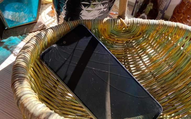 Zniszczony telefon leżący w wiklinowym koszyku.