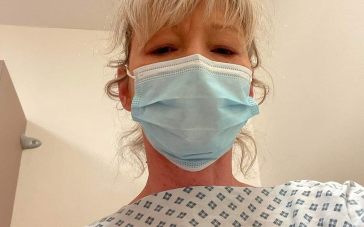 Kobieta w maseczce w szpitalnym fartuchu.