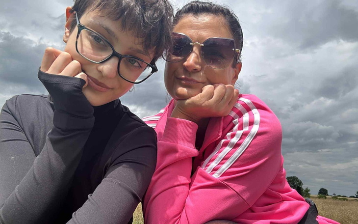 Dwie osoby pozujące do zdjęcia, uśmiechając się w plenerze.