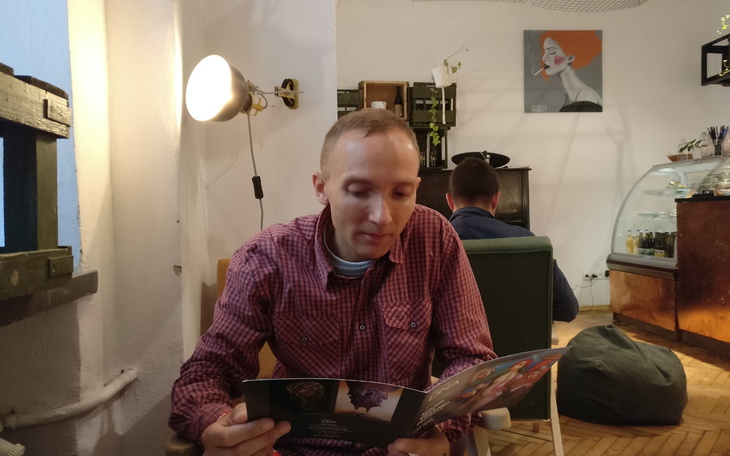 Mężczyzna przeglądający menu w kawiarni.