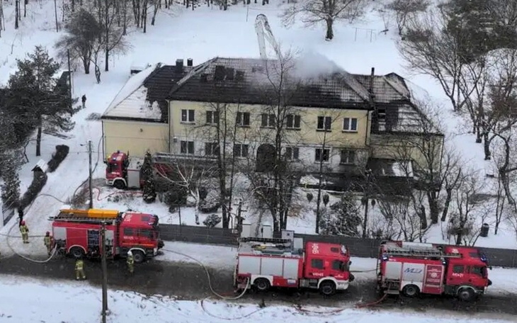 Pożar budynku, strażacy w akcji w zimowej scenerii.