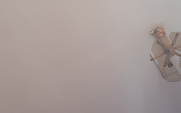 Zdjęcie sufitu z wentylatorem, w jasnych kolorach.