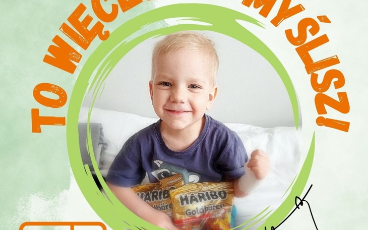 Uśmiechnięty chłopiec trzymający paczkę słodyczy.