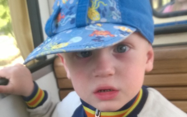 Chłopiec w niebieskiej czapce, patrzący z niepewnością.