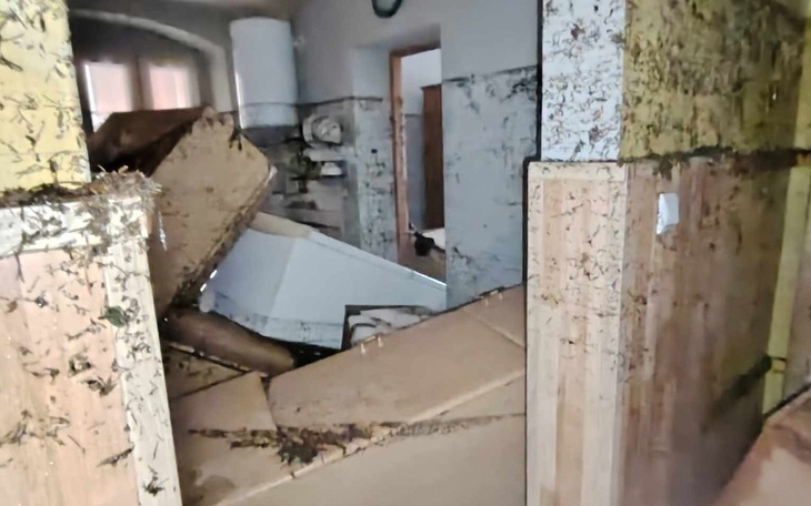 Zniszczone wnętrze pomieszczenia z kartonami.
