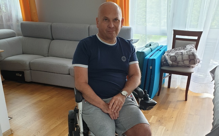 Mężczyzna na wózku inwalidzkim, siedzący w jasnym pomieszczeniu.