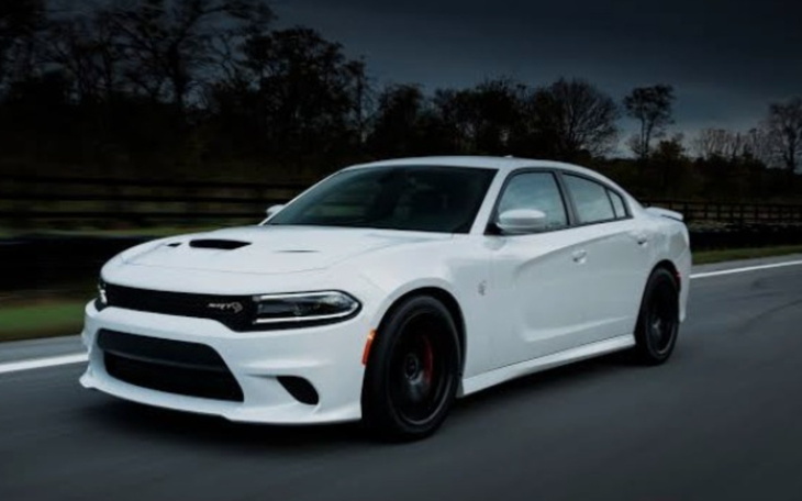 Biały samochód sportowy na drodze w ciemnym otoczeniu.