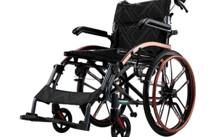 Wózek inwalidzki, czarny z brązowymi akcentami, na białym tle.