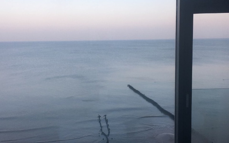 Widok na morze z okna, spokojna tafla wody.