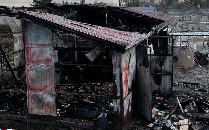Zniszczony budynek po pożarze, z widocznymi uszkodzeniami.
