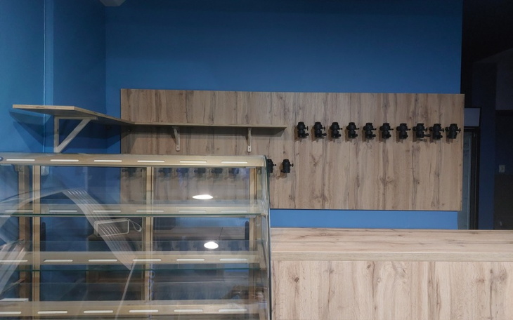 Wnętrze z niebieskimi ścianami i drewnianymi półkami.