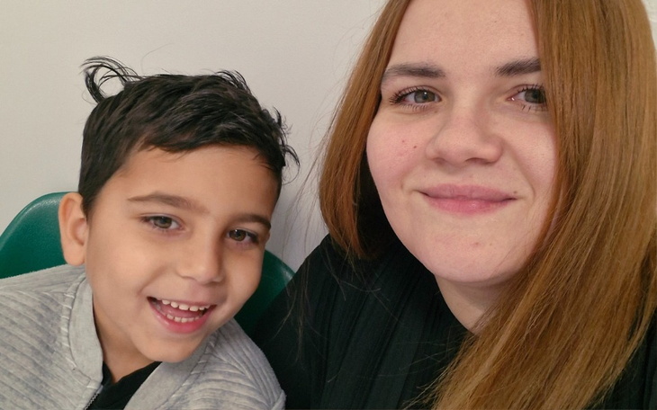 Uśmiechnięta kobieta z dzieckiem na zdjęciu.