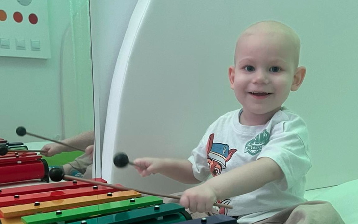 Mały chłopiec grający na cymbałkach w szpitalu.