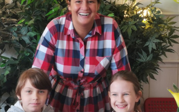 Uśmiechnięta kobieta z dwójką dzieci w restauracji.