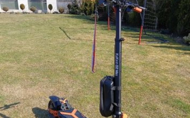 Skuter elektryczny z akcesoriami na trawie.