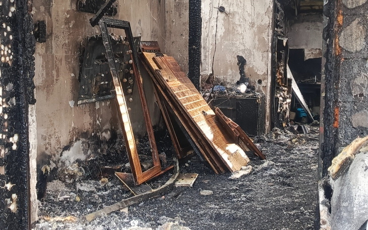 Zniszczony pokój po pożarze, z popalonymi meblami.